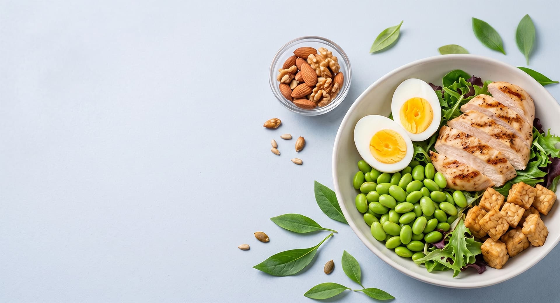 Healthy bowl with eggs, avocado, and greens on a wooden surface